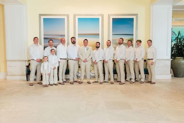 Groom and his groomsmen wearing sand colored slacks and casual white shirts paired with sandals for his Clearwater Beach wedding