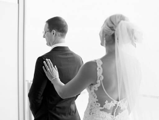 bride tapping her groom on the shoulder during their first look