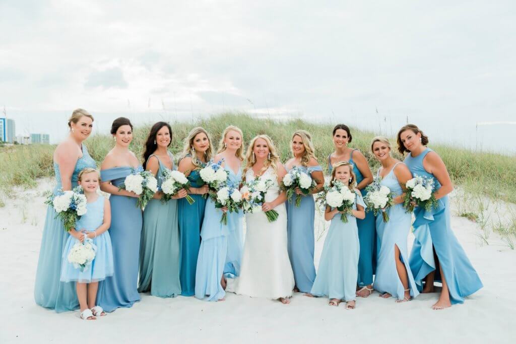 wedding party in shades of blue walking on Clearwater Beach from Special Moments Events instagram page