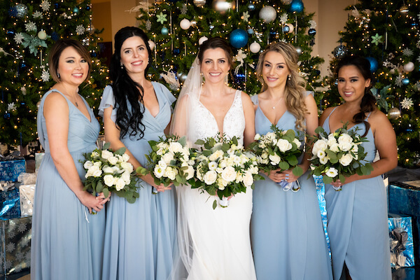 bride with her bridal party in the Opal Sands lobby during Christmas