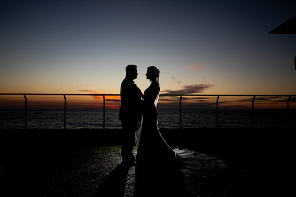 Shadowy photo of a bride and groom outside the Opal Sands Resort as the sun finishes setting and darkness falls