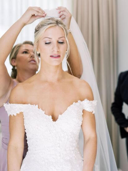 bridesmaid placing veil on bride at Harborside Chapel