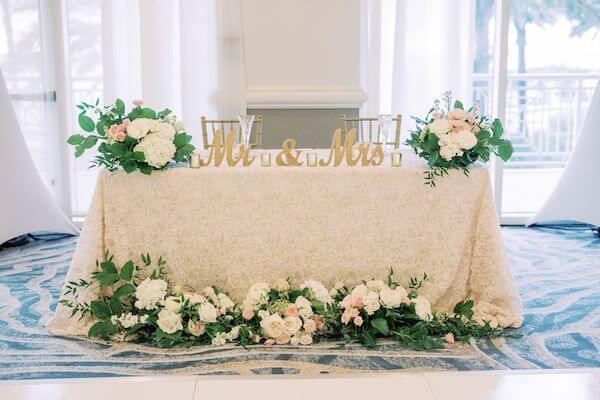 sweetheart table with lace linen and lush floral centerpieces