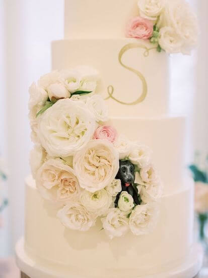 adorable puppy figurine peaking out of wedding cake