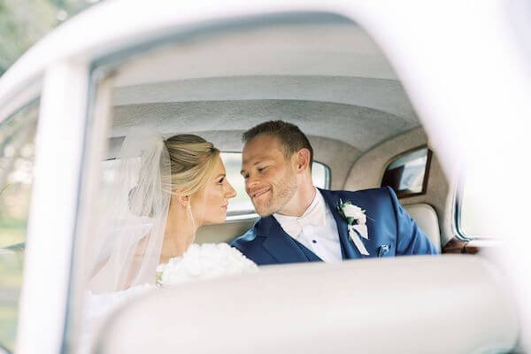 bride and groom in the back of a vintage white rolls Royce