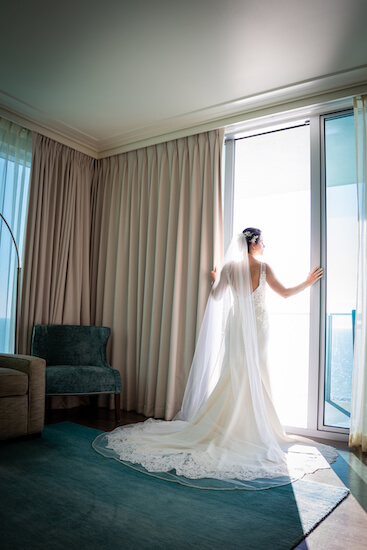 bride standing at the door of her Opal Sands Resort suite overlooking Clearwater Beach