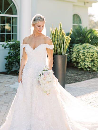 Bride at Harborshide Chapel wearing a lace ballgown with a pink and white bouquet 