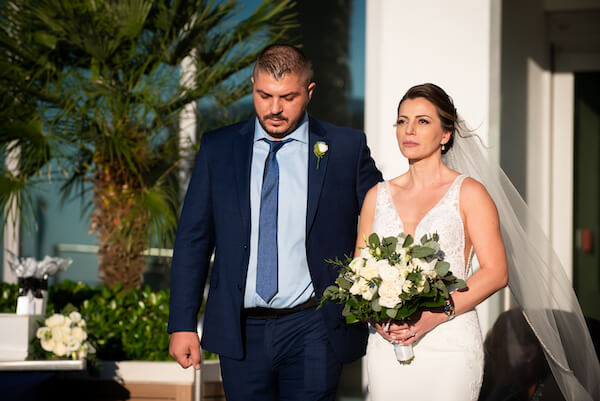 Clearwater Beach bride holding back tears as she walks down the aisle to her groom