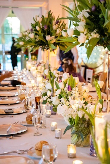 Banquet table filled with purple and white centerpieces at The Vault in Tampa