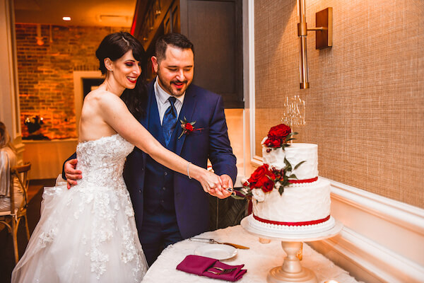 bride and groom cutting their wedding cake during their wedding reception in downtown St Pete