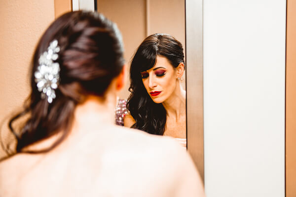 beautiful bride looking at her reflection in the mirror