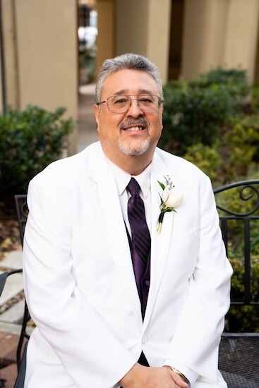 Tampa groom wearing a white suit jacket and dark purple necktie