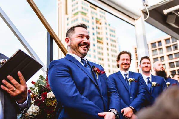 Groom smiling ear to ear as his bride approaches during their roof top wedding in downtown St Pete