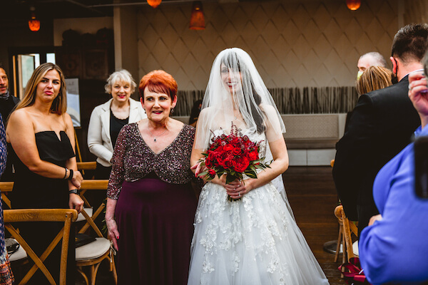 bride being escorted down the aisle of her downtown St Pete rooftop wedding