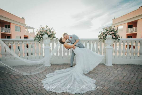 groom dipping his new bride as they take wedding photos on the sky terrace at the Hyatt Clearwater Beach