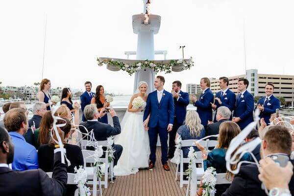 Newlyweds recessional in a flutter of ribbon wands on the upper deck of the Yacht StarShip in Tampa