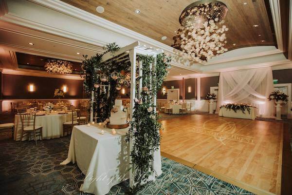 ballroom at the Hyatt Clearwater Beach set with a white trellis over a beautiful wedding cake