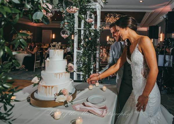 bride and groom cutting their gold drip wedding cake