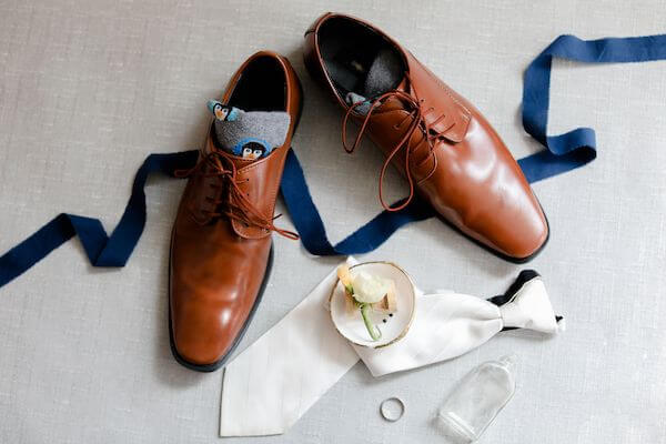 flatly photo of a grooms wedding accessories including penguin socks