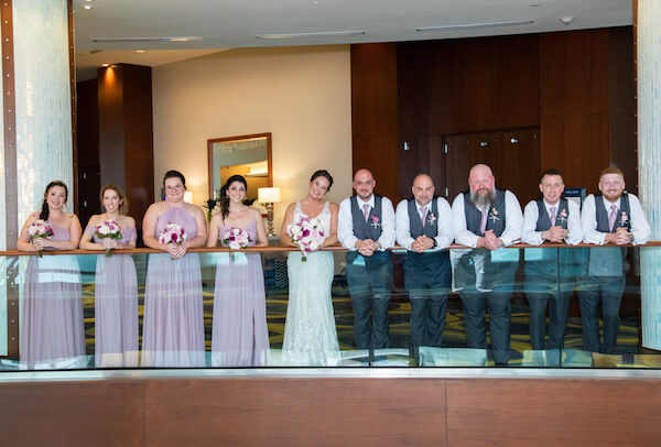 wedding party posing for photos on the second floor terrace of the Opal Sands Resort