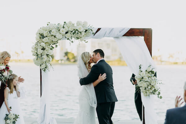 bride and groom sealing their wedding vows with a kiss in front of the boca Ciega bay