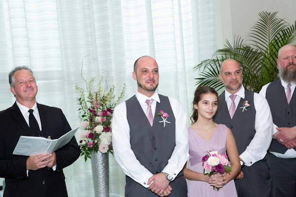 groom holding back tears as his bride walks down the aisle 