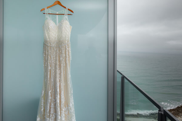 a sheet wedding gown with shimmering geometric lines handing on the balcony of the Opal Sands Resort