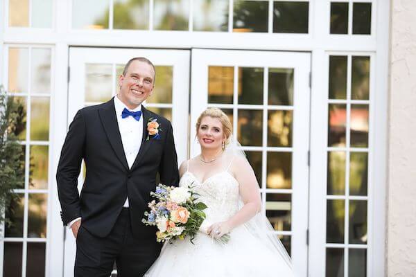 bride and groom posing for photos on the terrace of the Fenway Hotel in Dunedin Florida