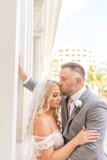 groom kissing his bride's forehead 