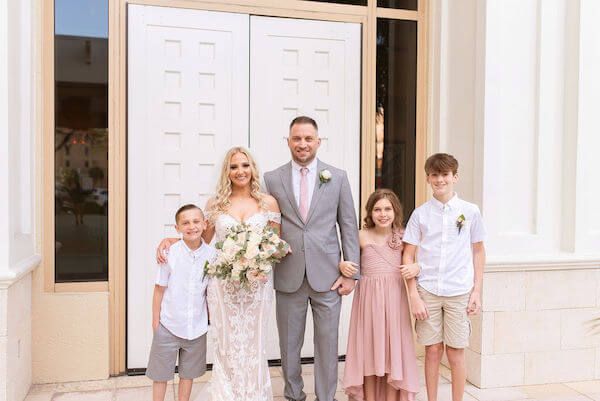 bride and groom taking photos with their children