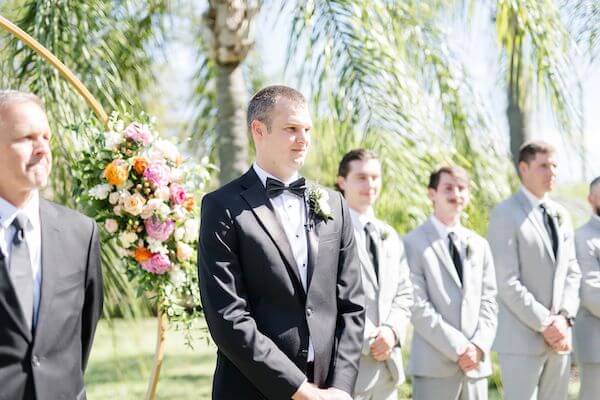 groom waiting in the garden for his bride to arrive