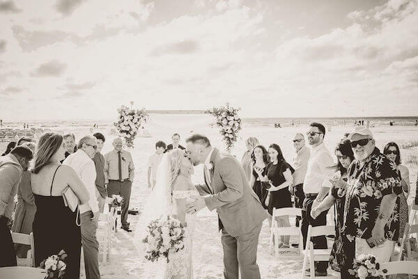 bride and groom kissing on CLEARWATER BEACH after their boho wedding ceremony