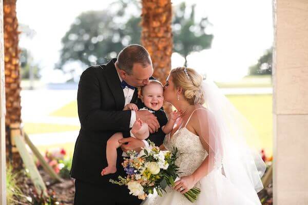 Bride and groom posing with their baby boy