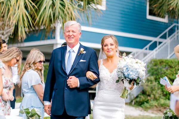 Bride's father walking her down the aisle at her Tampa Bay Watch wedding