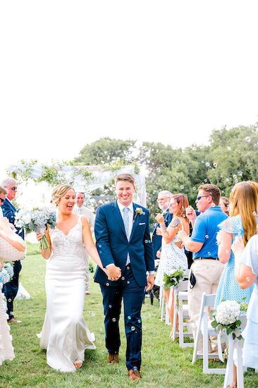 bride and groom exiting their Tampa Bay Watch wedding ceremony under a shower of bubbles