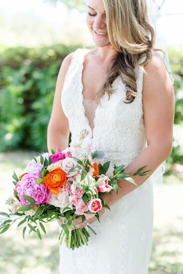 bride holding a beautiful garden inspired pink and orange bouquet