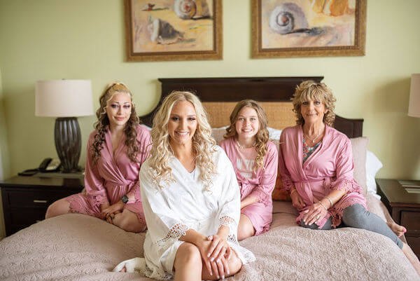 bride with mom and wedding party wearing boho styled robes with lace sleeves