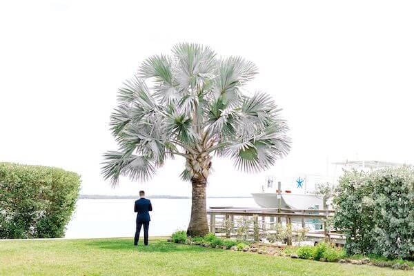 Groom facing the water at Tampa Bay Watch waiting for his bride to arrive