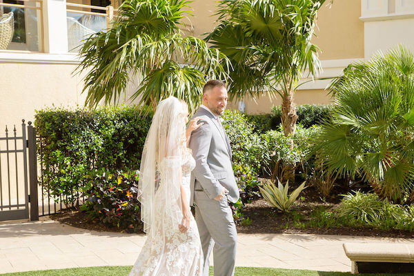 bride walking across the pool lawn at the Sand Pearl Resort to surprise her groom to be