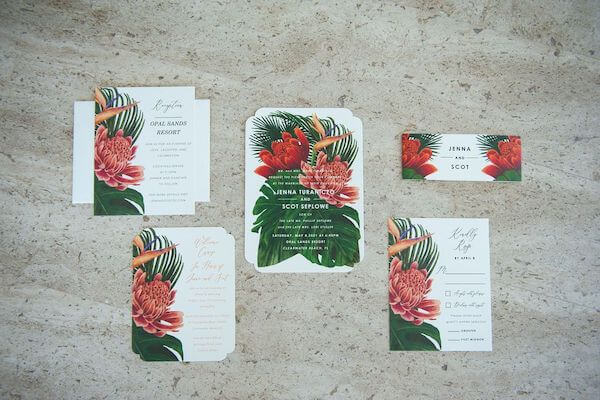 brightly colored wedding invitation suite with tropical flowers and leaves