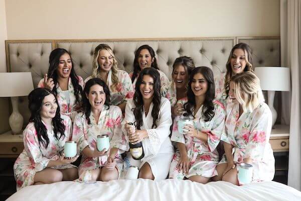 bride and burials party popping some champagne on her bed at the Opal Sands Resort