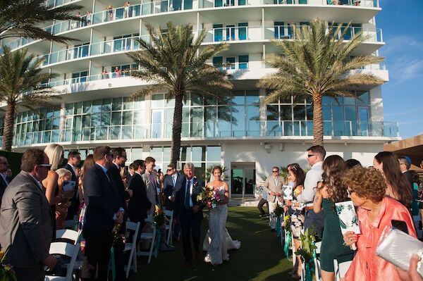 Bride being escorted down the aisle at her Opal Sands wedding ceremony