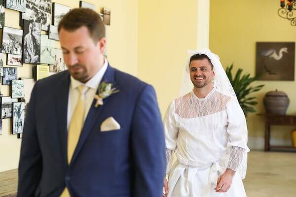 groomsmen dressed n a wedding gown surprising groom during his first look