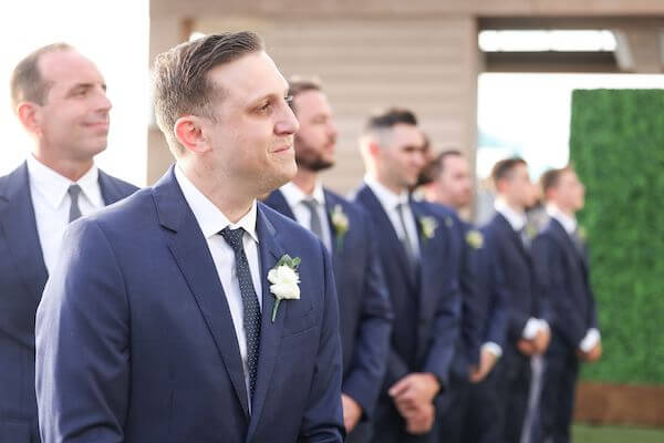 groom watching as his bride walks down the aisle at the Opal Sand Resort