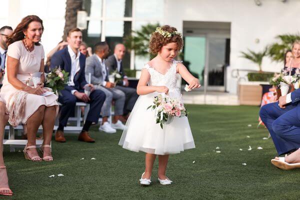 adorable flower girl sprinting petals down the aisle at the Opal Sands Resort