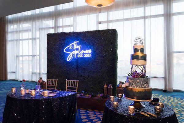 Neon sign, sweetheart table and wedding cake at the Opal Sands Resort