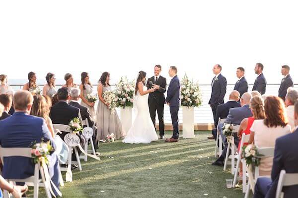 bride and groom exchanging wedding vows on the Gulf Lawn of the Opal Sands Resort