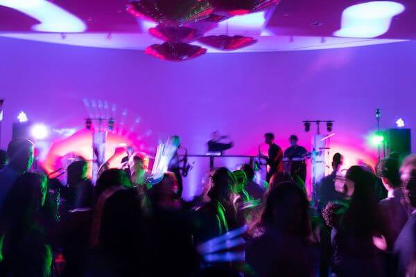 wedding guests with glow sticks dancing at an Opal Sands wedding reception