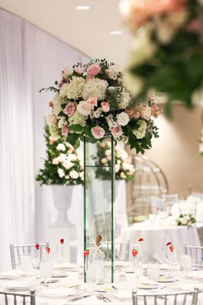 tall pink and white centerpieces resting on glass pillars