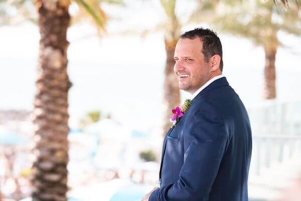 groom wearing a navy-blue suite with a tropical boutonniere